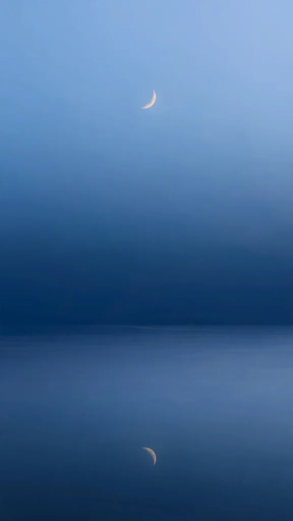 wallpaper aesthetic lock screen with crescent moon over calm blue night